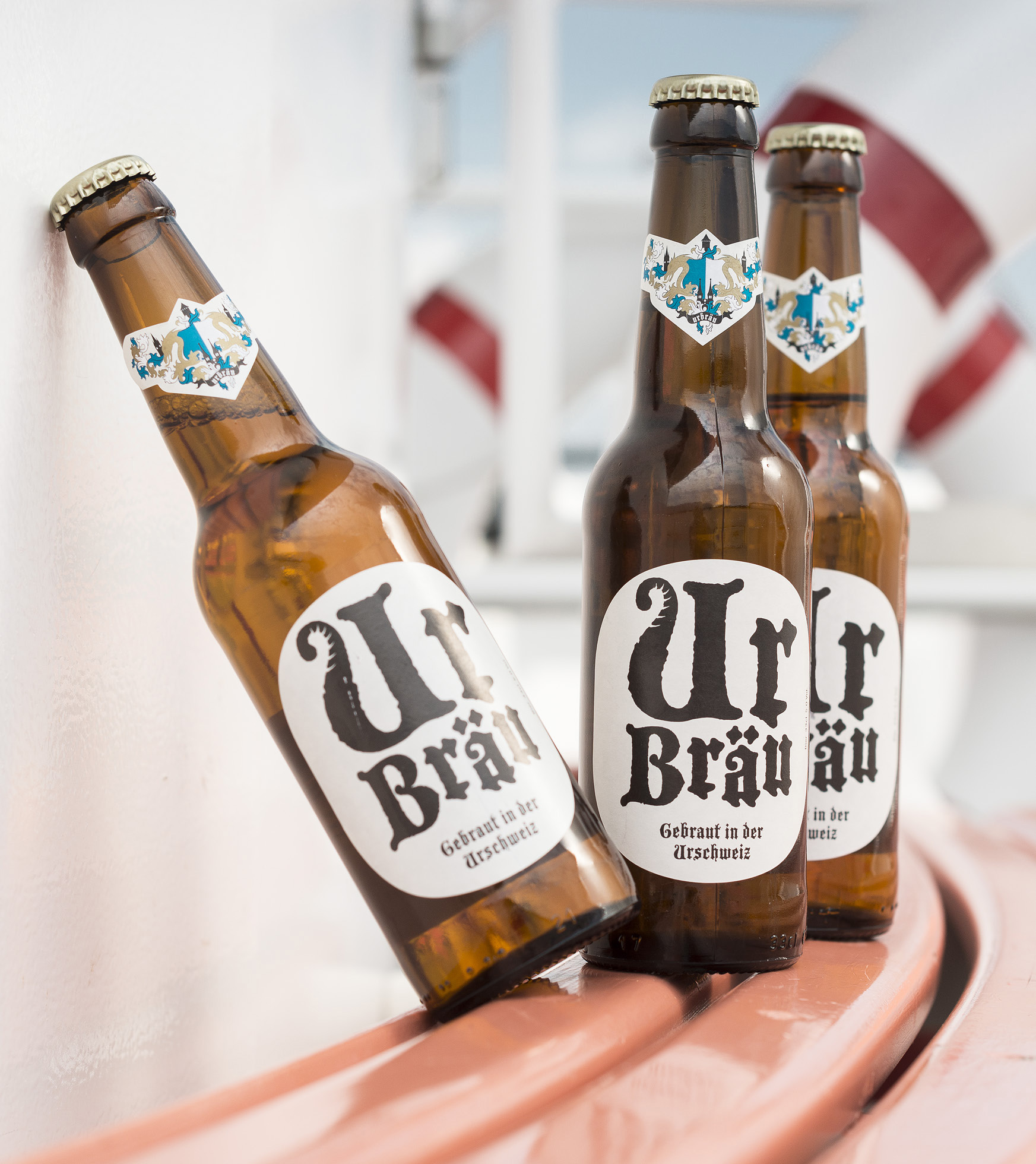 Drei Urbräu-Bierflaschen auf einer Sitzbank auf dem Schiff in Szene gesetzt.